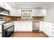 Bright kitchen featuring white cabinets, stainless steel appliances, and wood backsplash at 6811 Kluttz Rd, Concord, NC 28025