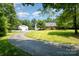 Wide paved driveway leading to a charming home with a garage and a large storage building at 6811 Kluttz Rd, Concord, NC 28025
