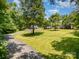 Expansive lawn and circular driveway leading to the home, surrounded by mature trees on a sunny day at 6811 Kluttz Rd, Concord, NC 28025