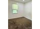 Bright bedroom featuring neutral walls, plush carpet, and a window for natural light at 6832 Delta Lake Dr, Charlotte, NC 28215