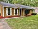 Charming home with yellow siding, white shutters, a walkway, and vibrant red landscaping at 6832 Delta Lake Dr, Charlotte, NC 28215