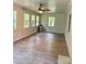 Open living room featuring hardwood floors, multiple windows and a ceiling fan at 6832 Delta Lake Dr, Charlotte, NC 28215