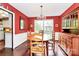 Cozy dining room with warm red walls, wooden furniture, and hardwood floors for a welcoming atmosphere at 7020 Leesburg Rd, Charlotte, NC 28215