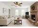 Bright living room featuring a brick fireplace, ceiling fan, and neutral-toned furniture at 7020 Leesburg Rd, Charlotte, NC 28215