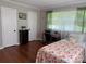 Inviting bedroom with hardwood floors, floral bedding, and lots of natural light at 708 East St # 89, Albemarle, NC 28001