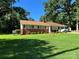 Well-maintained home with green lawn, landscaping, brick accents, and a covered carport, nestled among mature trees at 708 East St # 89, Albemarle, NC 28001