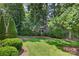 Secluded backyard featuring lush landscaping, mature trees, and a well-maintained lawn at 803 Woodmoore Ln, Kannapolis, NC 28081