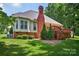 House with a large brick chimney, bay window, outdoor deck, and well-manicured backyard at 803 Woodmoore Ln, Kannapolis, NC 28081