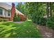 House with a large brick chimney, outdoor deck, and well-manicured backyard with mature trees at 803 Woodmoore Ln, Kannapolis, NC 28081