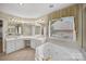 Elegant bathroom featuring a jetted tub, double vanity with large mirrors, and neutral tile floor at 803 Woodmoore Ln, Kannapolis, NC 28081