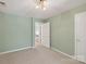 Bedroom with neutral carpet, light green walls, and access to the hallway at 803 Woodmoore Ln, Kannapolis, NC 28081