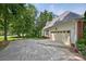 Two-car garage attached to a light-colored house in a yard with mature trees and landscaping at 803 Woodmoore Ln, Kannapolis, NC 28081