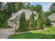 Brick home with attached garage surrounded by mature trees and lush green lawn at 803 Woodmoore Ln, Kannapolis, NC 28081