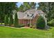 Brick front exterior with a charming porch, manicured lawn, and mature landscaping at 803 Woodmoore Ln, Kannapolis, NC 28081