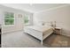 Bright bedroom featuring neutral decor, plush carpeting, and natural light from two large sunny windows at 835 Windage Way, Pineville, NC 28134
