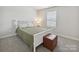 Inviting bedroom featuring neutral walls, a comfortable bed, and an ottoman near the window at 835 Windage Way, Pineville, NC 28134