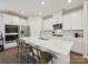 Bright kitchen featuring stainless steel appliances, an island with seating, white cabinets, and tile backsplash at 835 Windage Way, Pineville, NC 28134