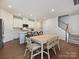 Bright, open-concept kitchen with an island, counter seating, stainless steel appliances, and wood floors at 835 Windage Way, Pineville, NC 28134