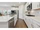 Bright, modern kitchen with white cabinets, stainless steel appliances, tile backsplash, and an island with sink at 835 Windage Way, Pineville, NC 28134