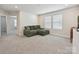 Spacious living room with plush green sectional sofa and sun-filled windows overlooking the neighborhood at 835 Windage Way, Pineville, NC 28134