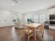 Open-concept living room and dining area with wood floors and a view of the modern kitchen appliances at 835 Windage Way, Pineville, NC 28134