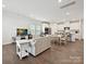 Bright, open-concept living room featuring wood floors and seamless flow to the kitchen and dining area at 835 Windage Way, Pineville, NC 28134