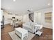 Bright living room featuring wood floors, a staircase, and a seamless flow to the open-concept kitchen at 835 Windage Way, Pineville, NC 28134