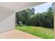 Covered patio opens to a spacious, grassy backyard bordered by a serene wooded area at 8680 Sherrills Ford Rd, Sherrills Ford, NC 28673