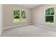 Bright bedroom featuring neutral walls, plush carpet, and scenic views through multiple windows at 8680 Sherrills Ford Rd, Sherrills Ford, NC 28673