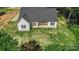 New construction featuring white vertical siding, dark roof, and manicured lawn at 8680 Sherrills Ford Rd, Sherrills Ford, NC 28673