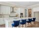 Bright kitchen with white cabinets, stainless steel appliances, and a large island with stylish blue chairs at 8680 Sherrills Ford Rd, Sherrills Ford, NC 28673