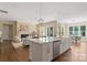 A kitchen with a large island with white cabinets and view into the open concept living and dining area at 8680 Sherrills Ford Rd, Sherrills Ford, NC 28673