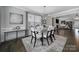 Dining room with modern chandelier, table and chairs, large window, and access to living area at 8702 Aspinwall Dr, Charlotte, NC 28216