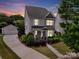 Charming two-story home with landscaped yard, stone accents, and detached garage at sunset at 8702 Aspinwall Dr, Charlotte, NC 28216