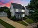 Charming two-story home featuring gray siding, stone accents, a manicured lawn, and a detached garage at 8702 Aspinwall Dr, Charlotte, NC 28216