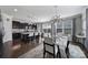 Modern kitchen and dining area with dark cabinets, granite countertops, and pendant lighting at 8702 Aspinwall Dr, Charlotte, NC 28216