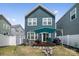 Private backyard featuring a wooden deck, fire pit, and white picket fence at 9025 Henry Thoreau Rd, Charlotte, NC 28214