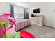 This bedroom features plush neutral carpeting, white trim, and a television at 9025 Henry Thoreau Rd, Charlotte, NC 28214