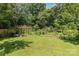 Spacious backyard with a lush green lawn and plenty of mature trees at 9520 Marshbrooke Rd, Matthews, NC 28105