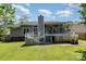 Back exterior with a wooden deck, screened in porch and a lush green lawn at 9520 Marshbrooke Rd, Matthews, NC 28105