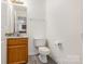 Bathroom featuring a light marble countertop, toilet and dark wood cabinets at 9664 Littleleaf Dr, Charlotte, NC 28215