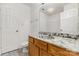 Bathroom with a light marble countertop, mirror, toilet, and dark wood cabinets at 9664 Littleleaf Dr, Charlotte, NC 28215
