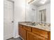 Bathroom vanity with granite countertops, a large mirror, and wooden cabinetry at 9664 Littleleaf Dr, Charlotte, NC 28215