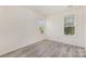 Bright bedroom featuring windows allowing natural light and light gray vinyl flooring at 9664 Littleleaf Dr, Charlotte, NC 28215