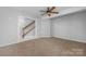 Spacious bedroom with neutral carpet, ceiling fan, and natural light from a nearby window at 9728 Blossom Hill Dr, Huntersville, NC 28078