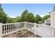Outdoor deck area with white wooden railing, overlooking a green, tree-filled backyard at 9728 Blossom Hill Dr, Huntersville, NC 28078