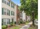 Charming townhome with brick facade, white siding, green shutters, and landscaped front yard at 9728 Blossom Hill Dr, Huntersville, NC 28078