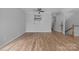 Spacious living room with wood flooring, ceiling fan, and a staircase in the background at 9728 Blossom Hill Dr, Huntersville, NC 28078