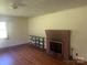 Cozy living room featuring hardwood floors, a brick fireplace, and natural light at 10010 Stokes Ferry Rd, Gold Hill, NC 28071