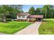 Inviting home with lush green lawn, convenient carport, and mature trees, offering a blend of comfort and charm at 103 Little Forest Ln, Statesville, NC 28625